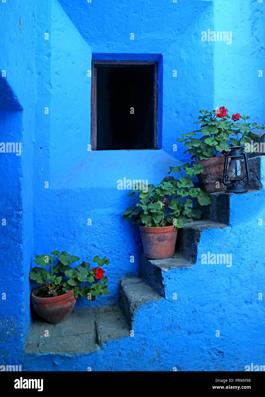 Impressive vivid blue colored staircase with the red flower planters in Monastery of Santa Catalina, Arequipa, Peru Stock Photo