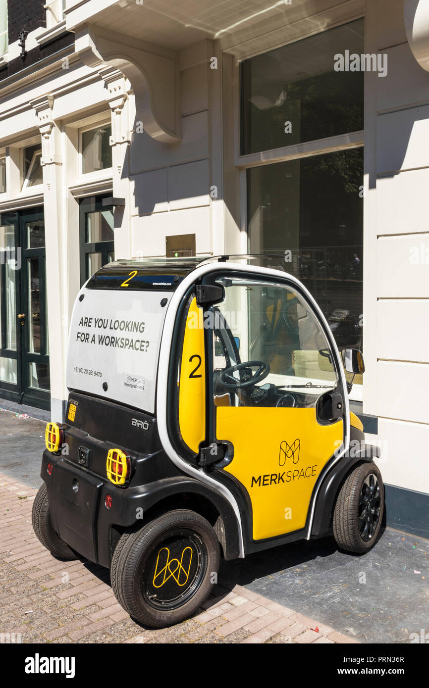 Amsterdam an Estrima Birò a four-wheeled electric vehicle with two seats side by side an electric moped parked outside an office Herengracht Amsterdam Stock Photo