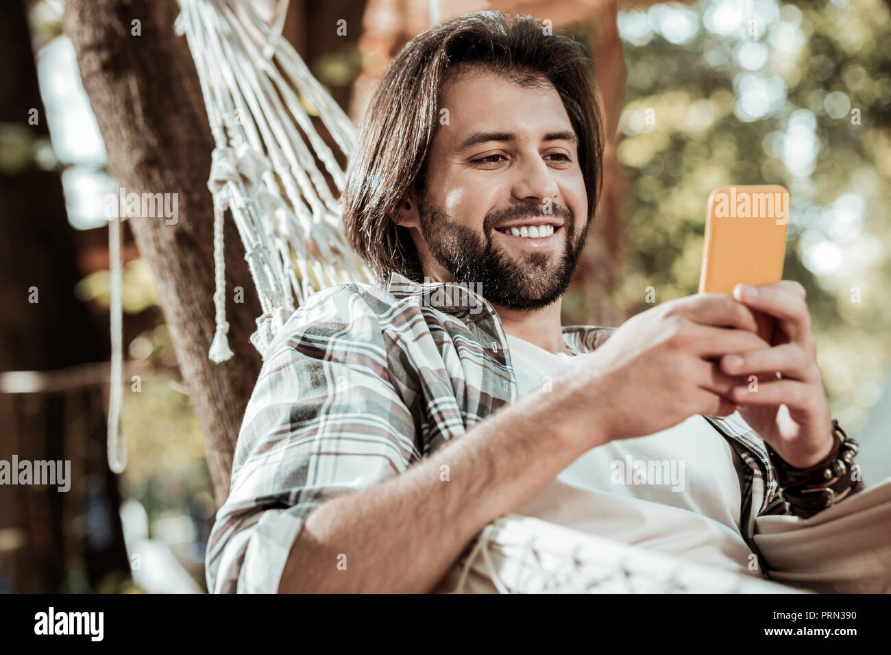 Happy young man texting with his friends Stock Photo