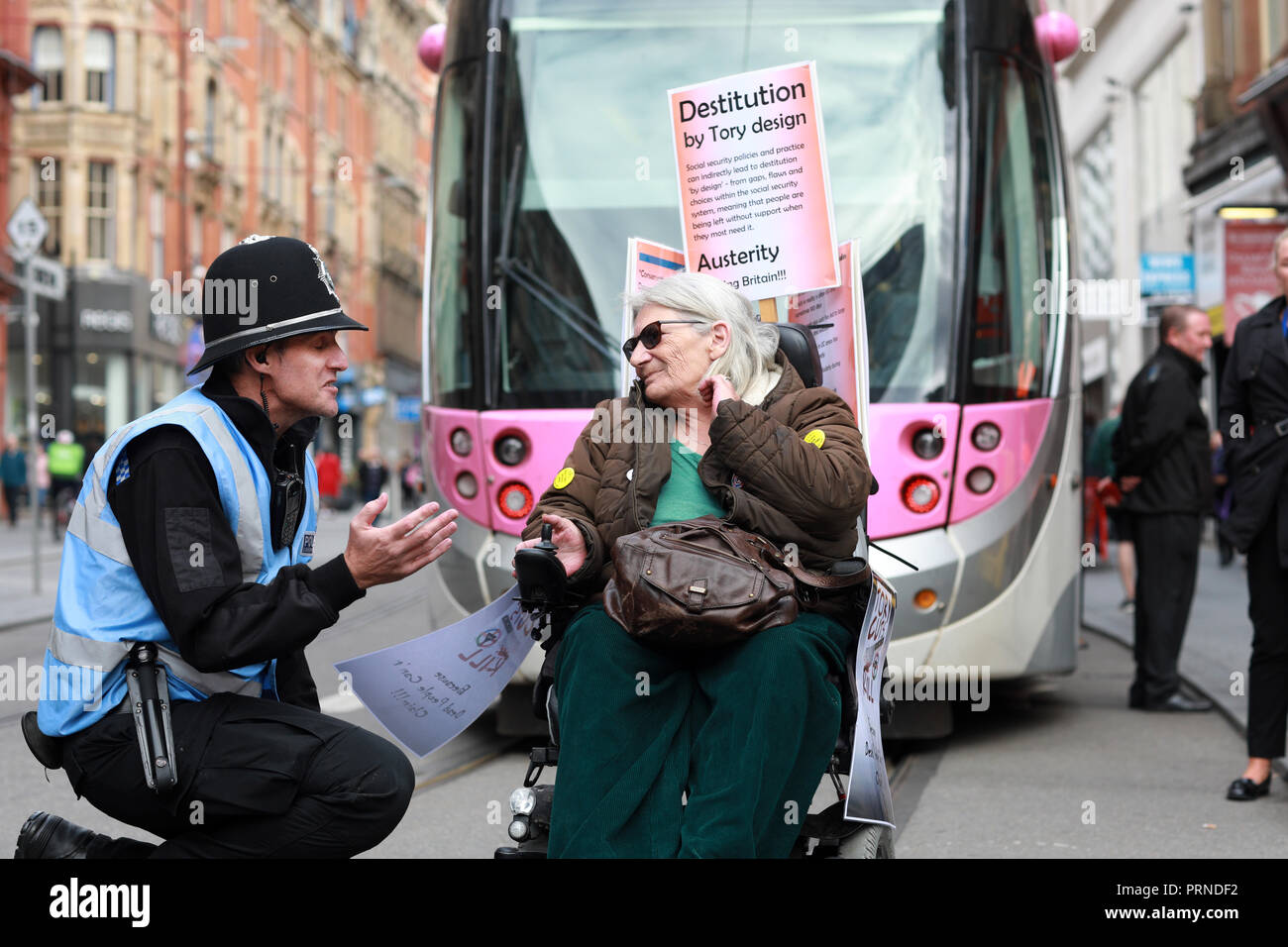 Birmingham, UK. 3rd October, 2018. Police try to negotiate with disabled rights protestors who blocked the main tramline out of Birmingham New Street station for about an hour yesterday afternoon  .They were demonstrating against the Conservative Government implimentation of austerity cuts . Research by the Joseph Rowntree Foundation found around 650,000 people with mental and physical health problems were officially destitute in the UK last year. Credit: Paul Pickard/Alamy Live News Stock Photo