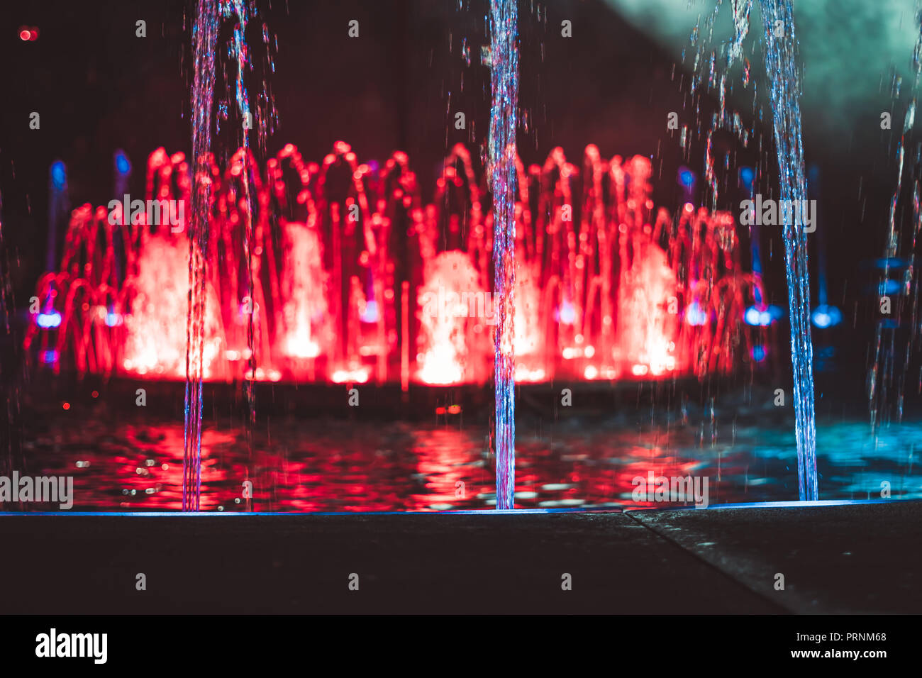 Colored water fountain at night Stock Photo - Alamy
