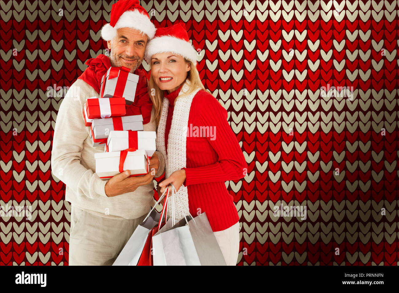 Composite image of happy festive couple with gifts and bags Stock Photo