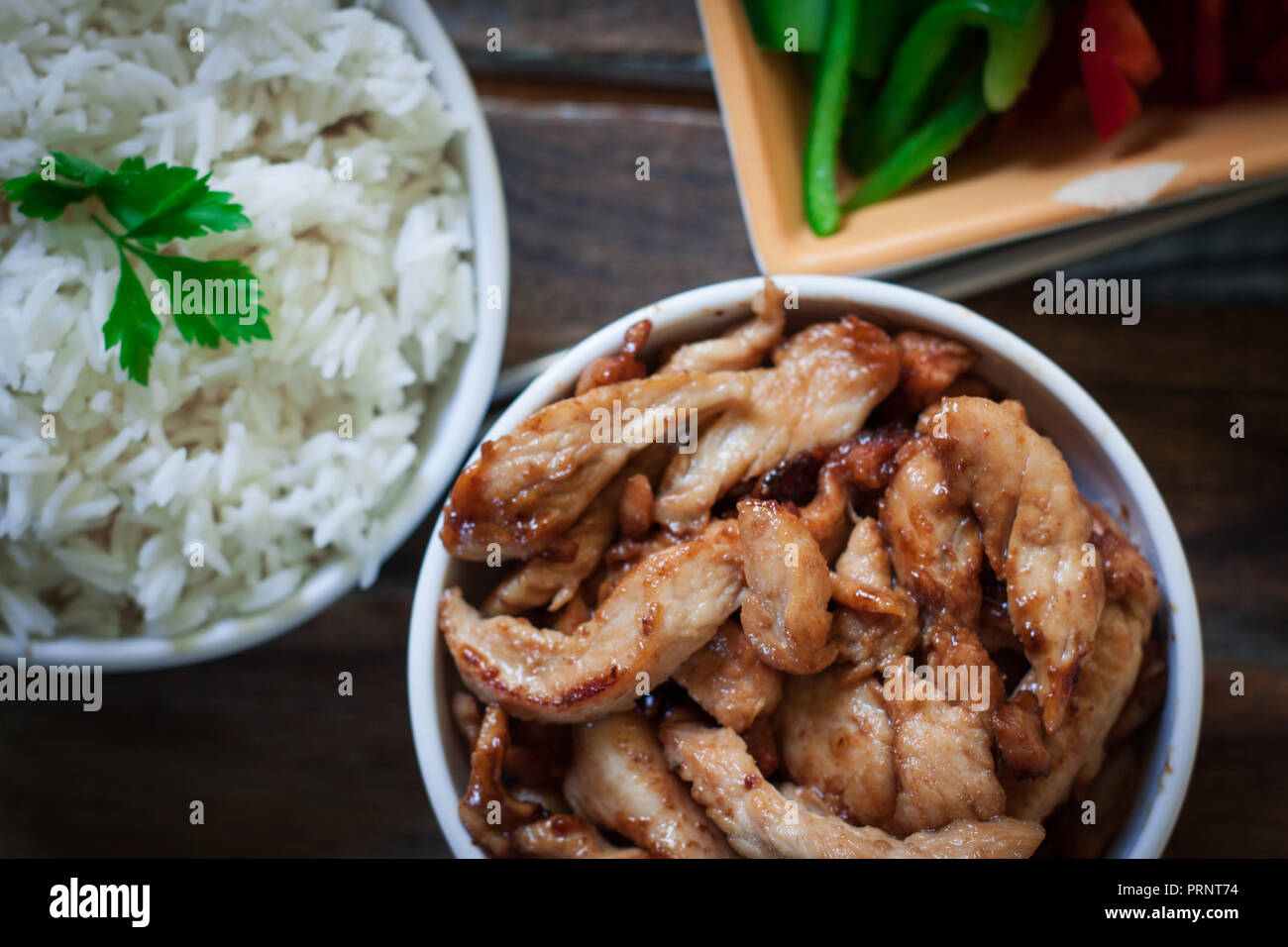 chinese chicken with soy sauce and a bowl of rice and a tablet for work ...