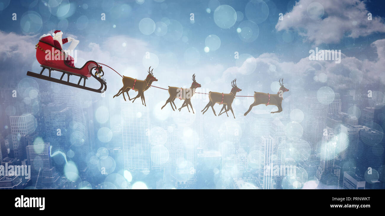 Composite image of side view of santa claus riding on sleigh during christmas Stock Photo