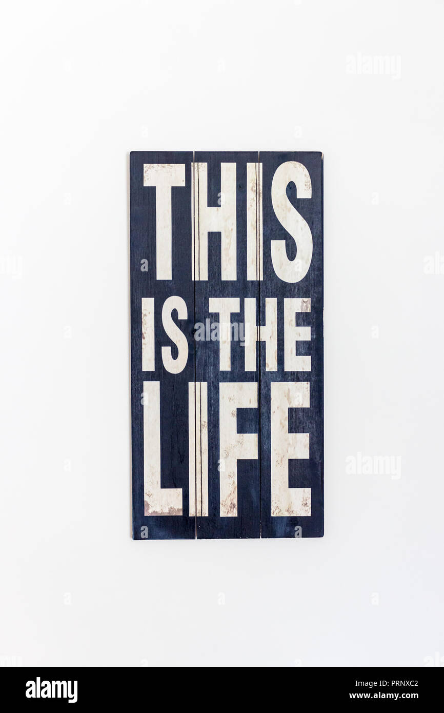This Is The Life Printed/ Painted on rustic black  wooden surface and white lettering, isolated on white background Stock Photo