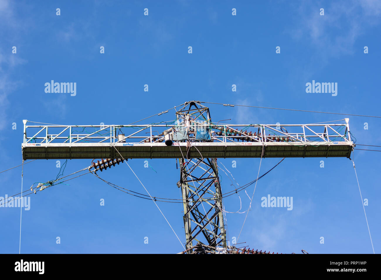 A temporary work platform attached to an electricity pylon for workers to carry out power line replacement Stock Photo