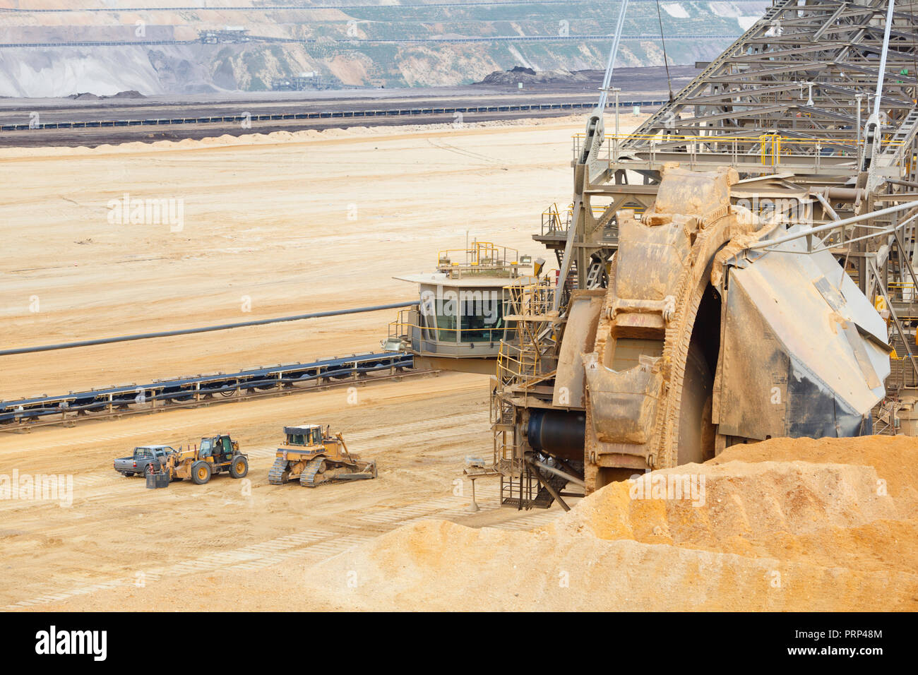 A lignite pit mine with a giant bucket-wheel excavator, one of the worlds largest moving land vehicles. The little cars and construction vehicles show Stock Photo