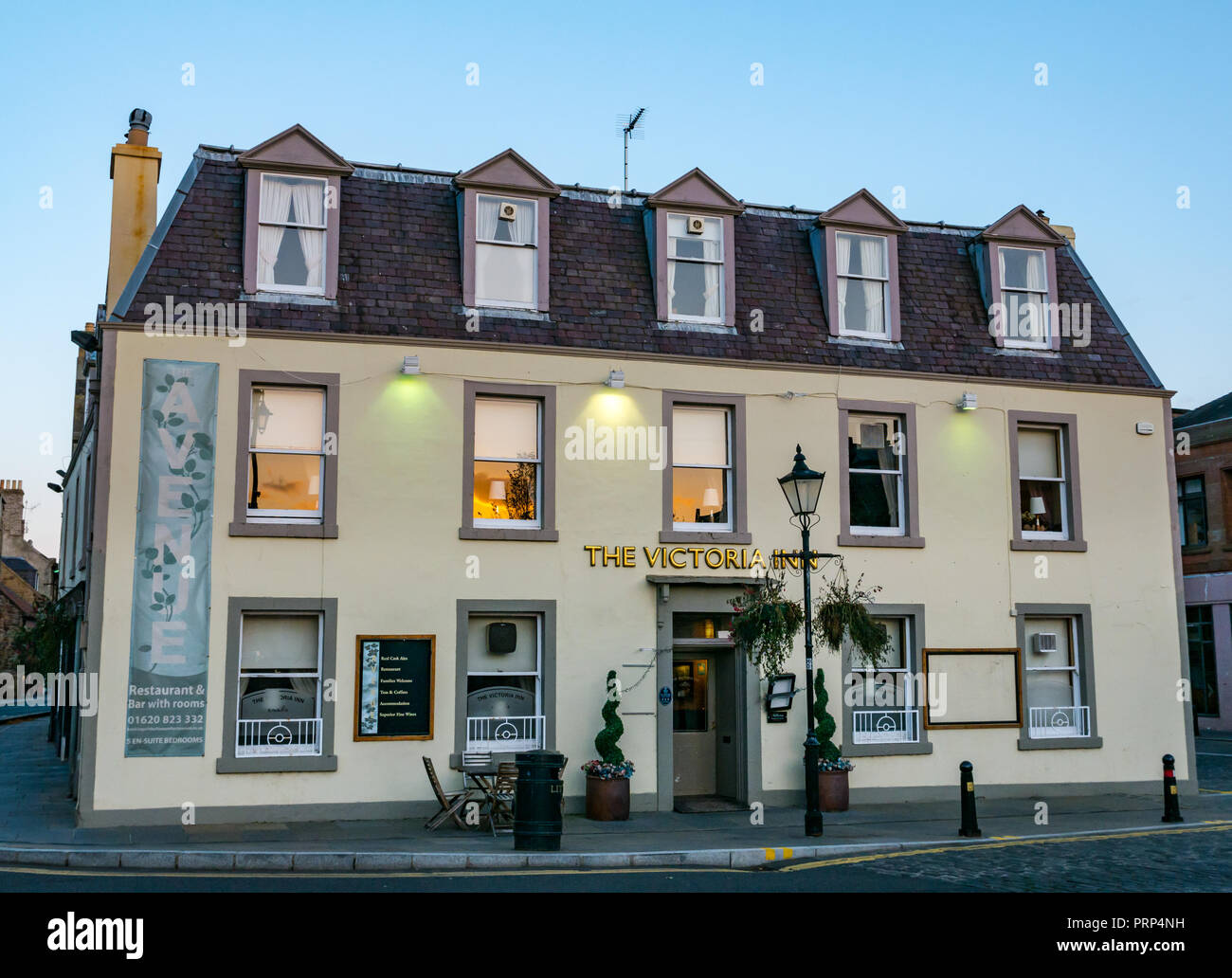 The Victoria Inn pub, bar, restaurant and B&B lit up at dusk, Court Street, Haddington, East Lothian, Scotland, UK Stock Photo