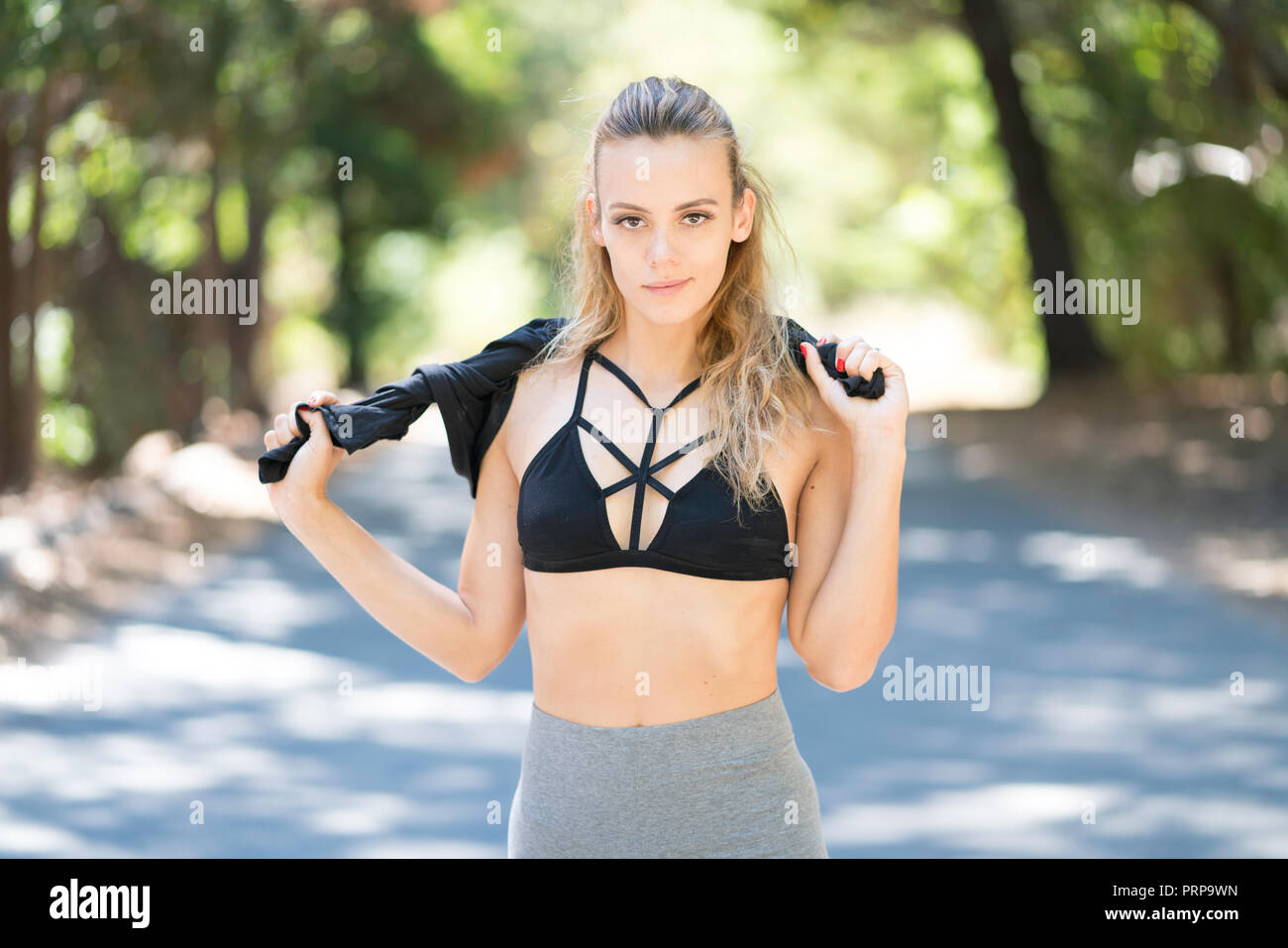 Young fit woman in sports bra and workout pants, wearing boxing