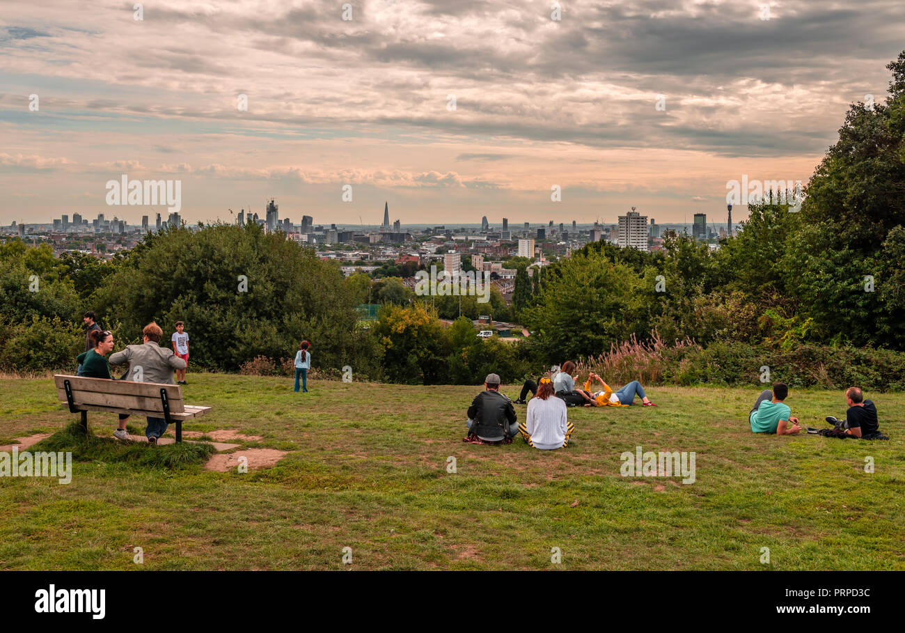 People have fun and enjoy the London skyline from the top of Parliament Hill, in Hampstead Heath, in north-west London. Stock Photo