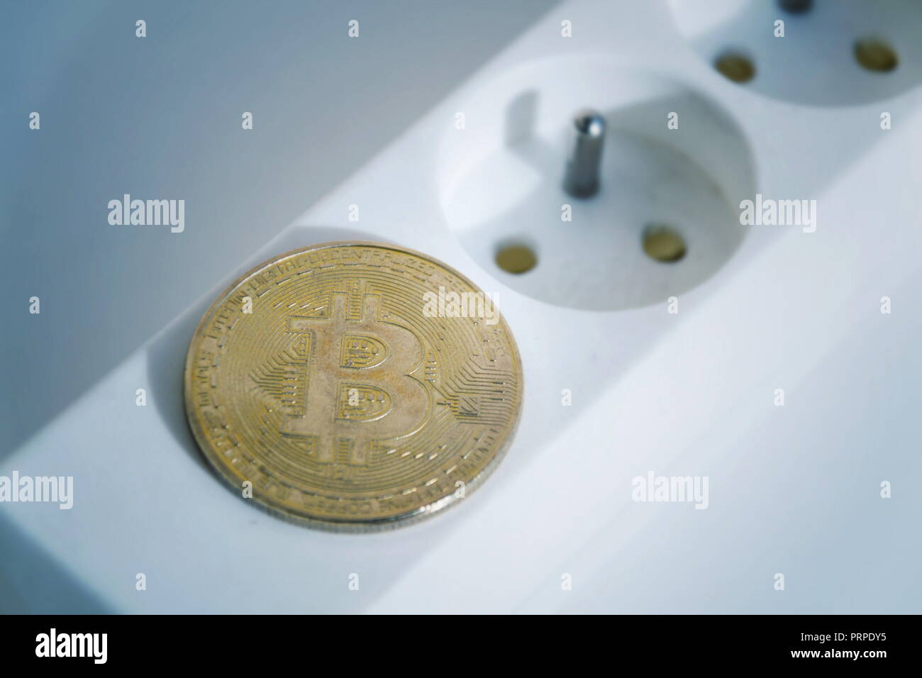 Bitcoin coin lying on power strip extension cord with two empty sockets,  cryptocurrency investing, energy consumption and footprint concept,  isolated Stock Photo - Alamy