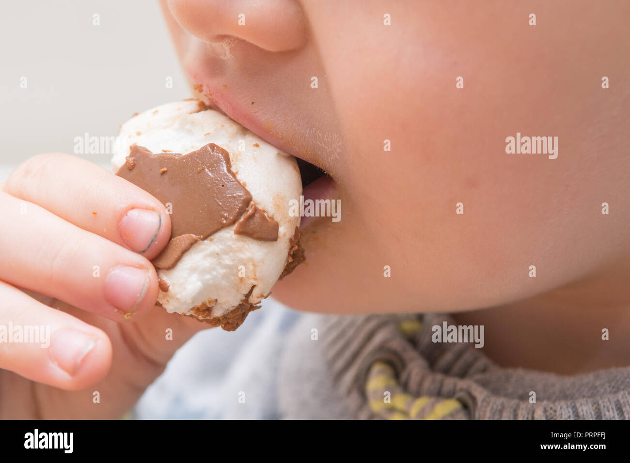 Young child eating a sugary chocolate snack Stock Photo