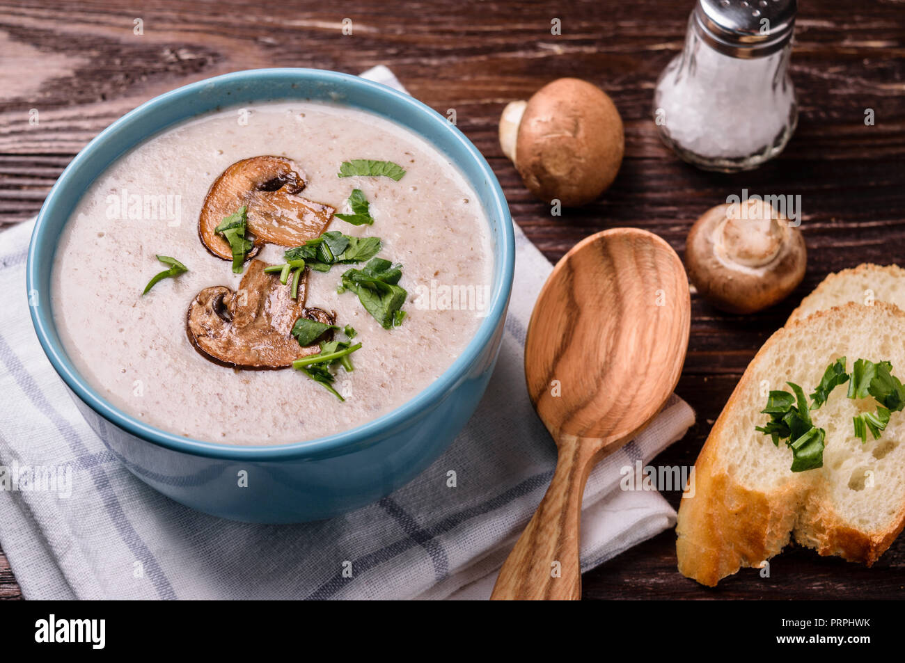 Delicious champignon mushroom cream soup puree on rustic wooden table. Stock Photo