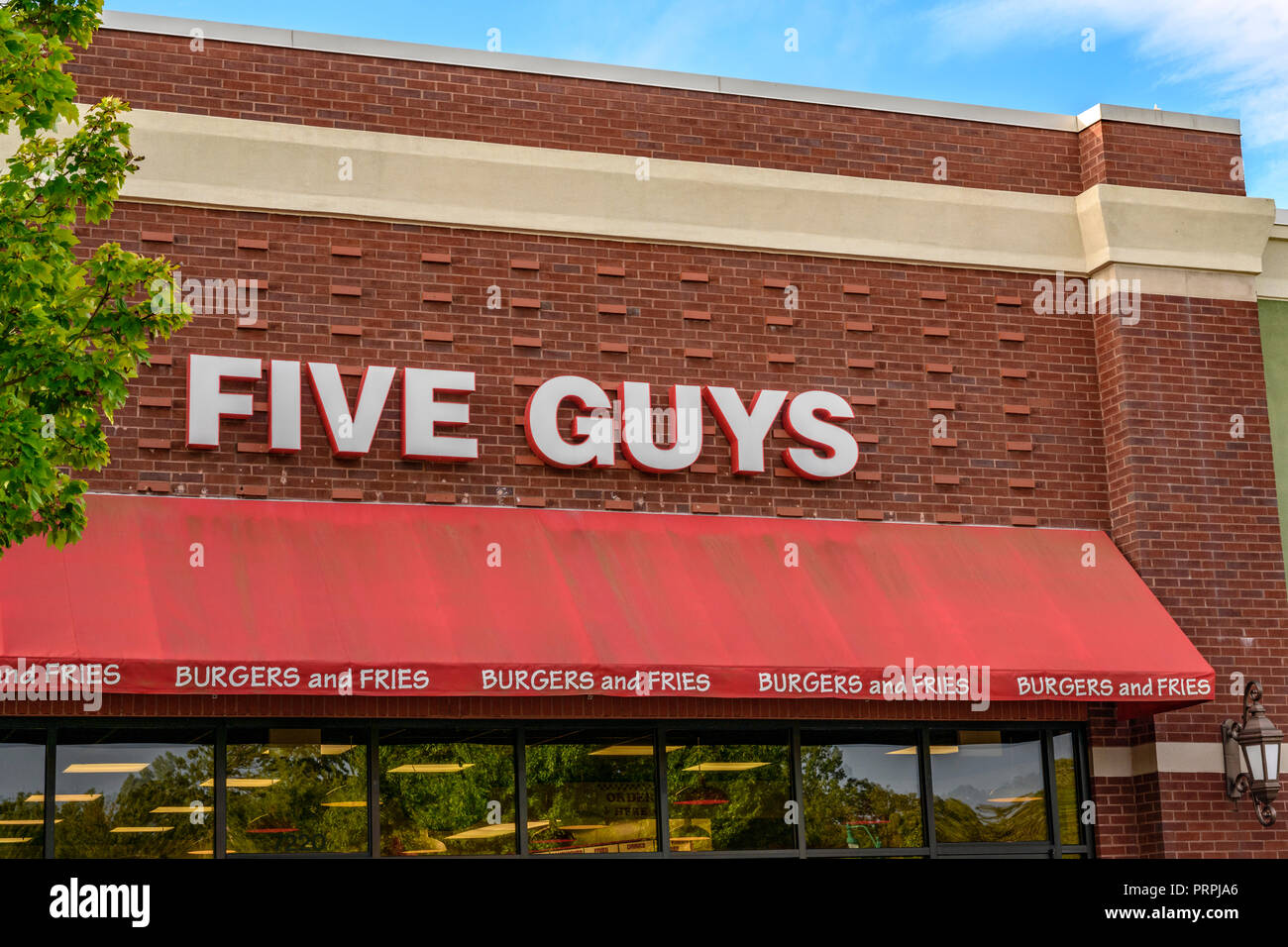 Five Guys hamburger restaurant front exterior entrance of the chain restaurant showing the corporate sign and logo in Montgomery, Alabama USA. Stock Photo