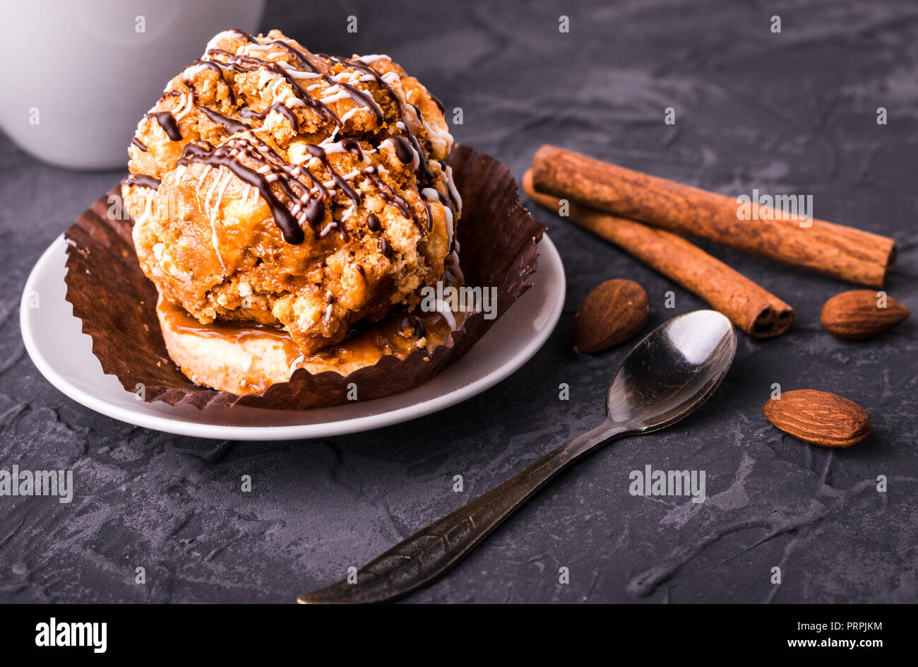 Delicious small cake dessert with caramel and chocolate. Close up view. On dark concrete stone background. Stock Photo
