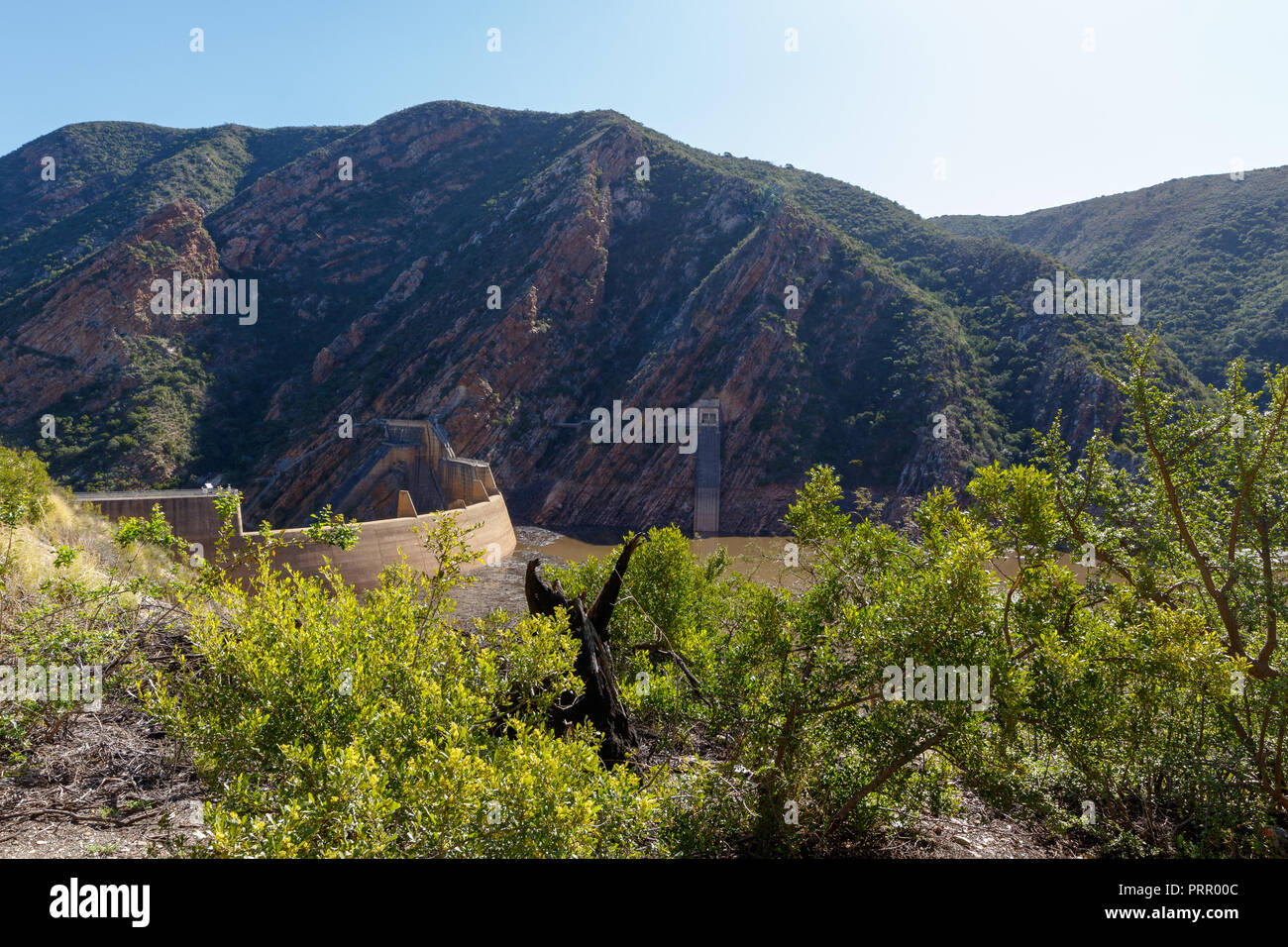 The view of the dam with bushes and mountains in the background Stock Photo