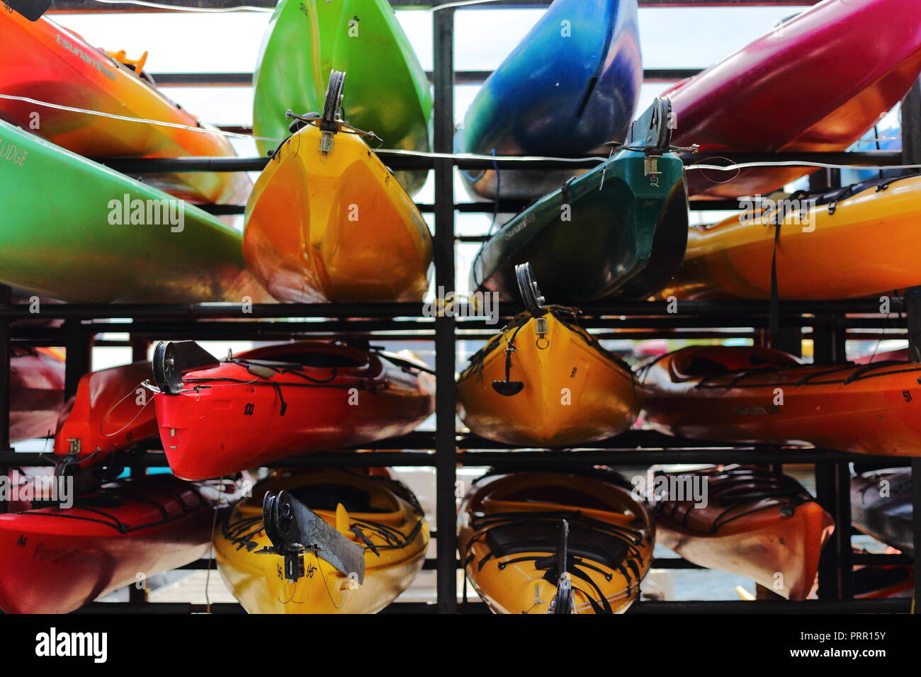 Bright and colorful canoes and kayaks stacked up on the waterfront at