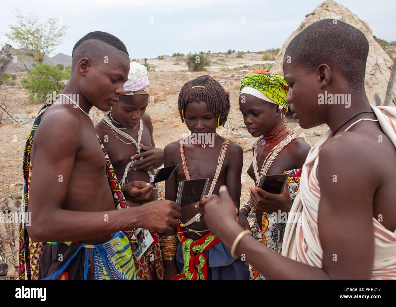 Mucubal Tribe People Looking At Polaroids Namibe Province Virei Angola Stock Photo Alamy