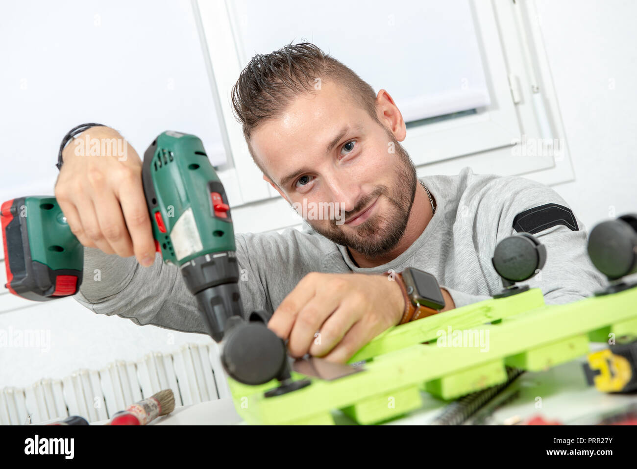 a young man DIY using electric drill Stock Photo