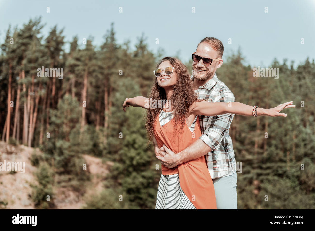 Beaming happy loving couple enjoying their secret hideaway in the forest Stock Photo