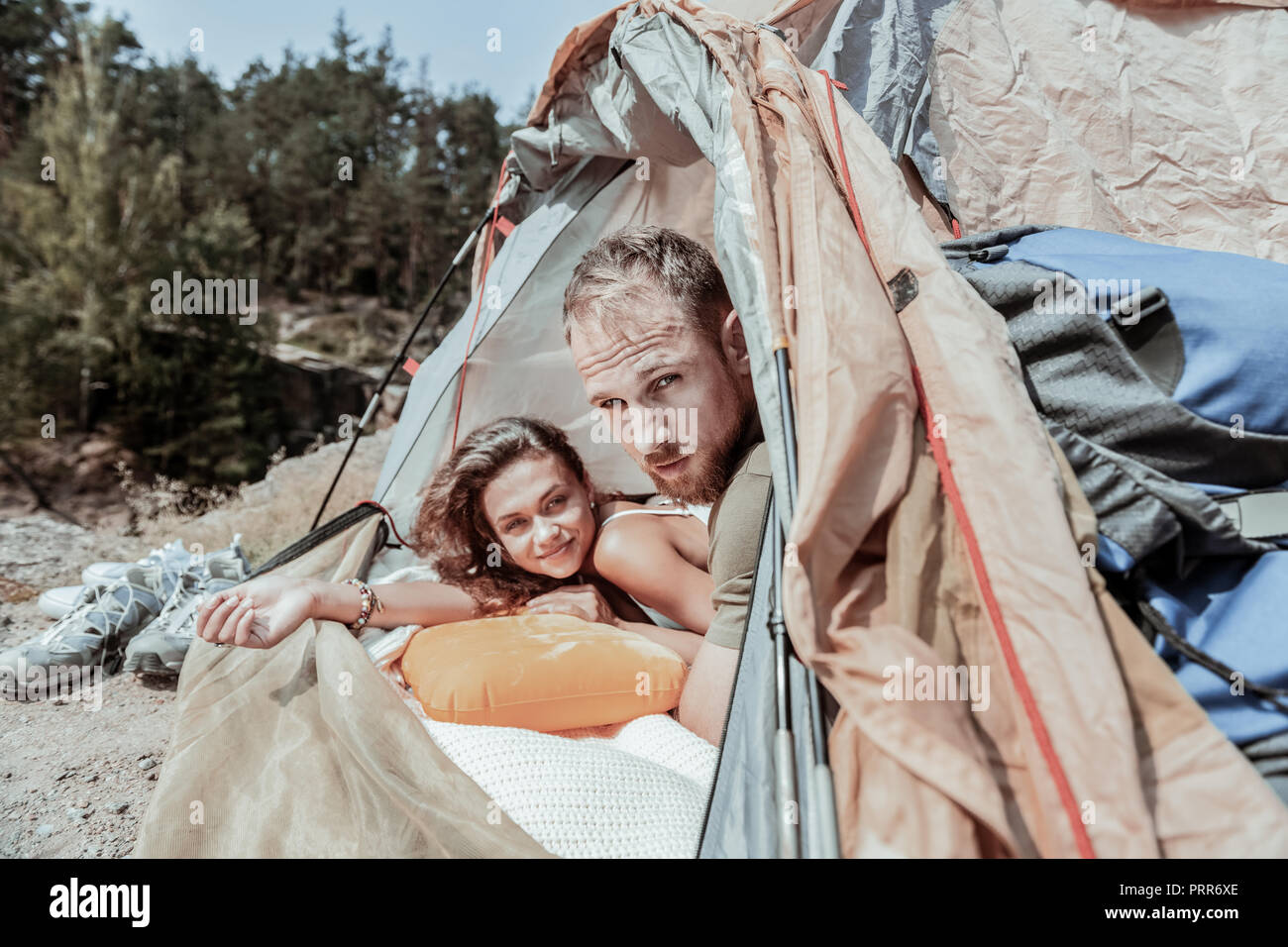 Couple of young active backpackers feeling sleepy after long cold night in tent Stock Photo