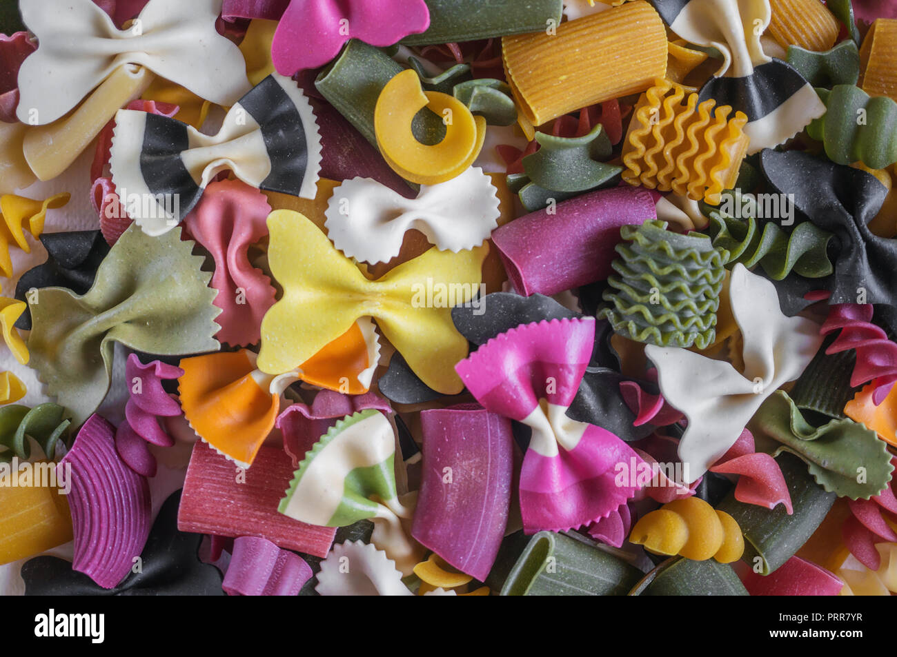 Mixed set of dry multi-colored Italian pasta on a white old wooden box. Background. Close up. Stock Photo