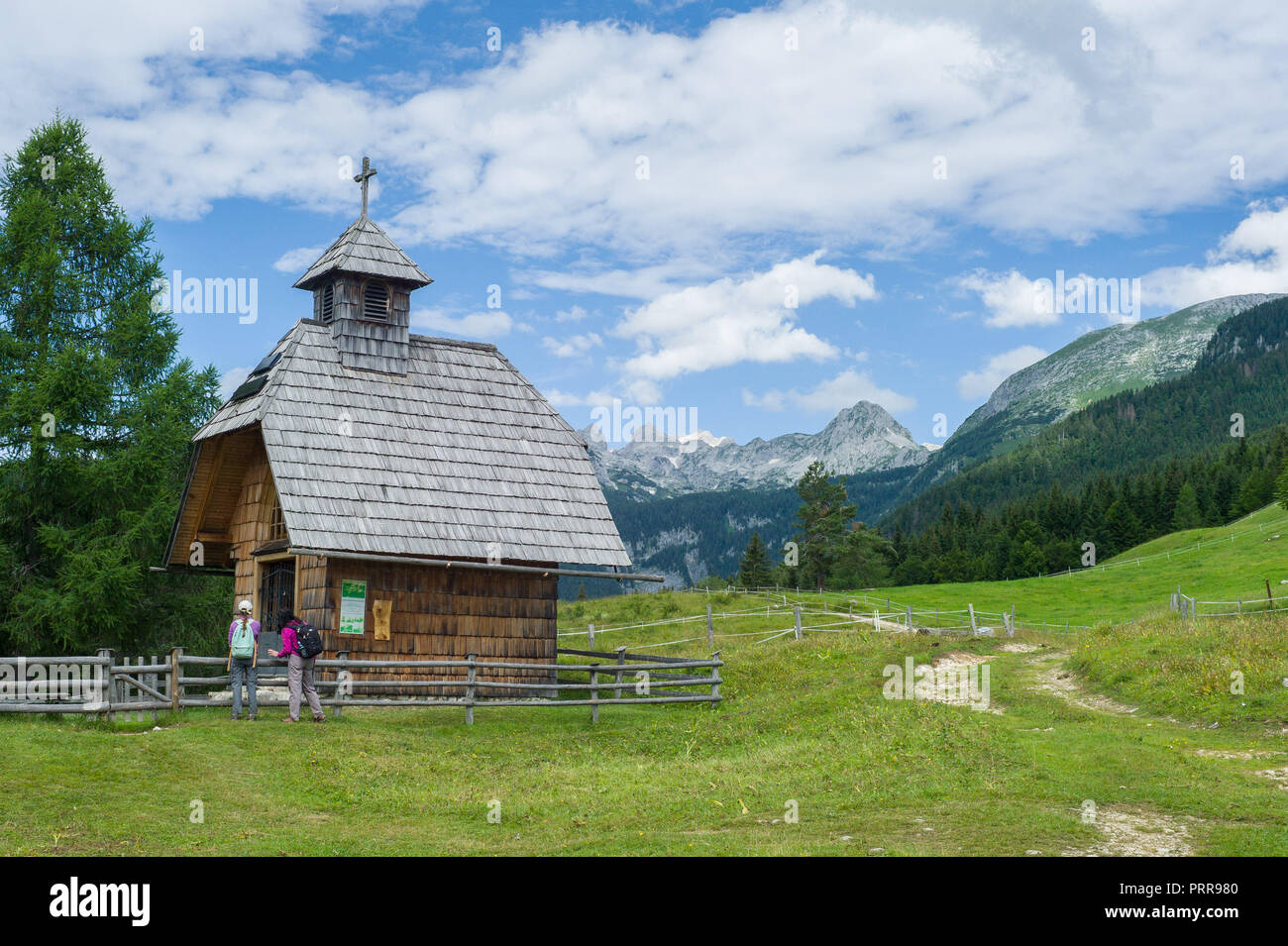 A chapel on the outskirts of Uskovnica, pokljuka plateau with Triglav mountain behind.  Julian Alps Slovenia Stock Photo