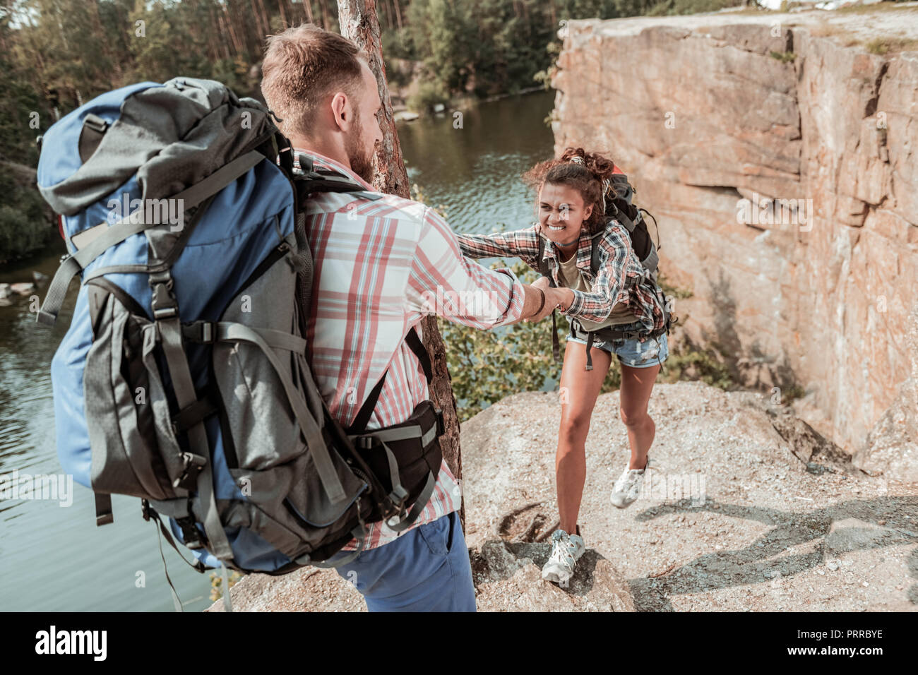 Curly dark-haired woman with heavy backpack feeling tired hiking with her  man Stock Photo - Alamy