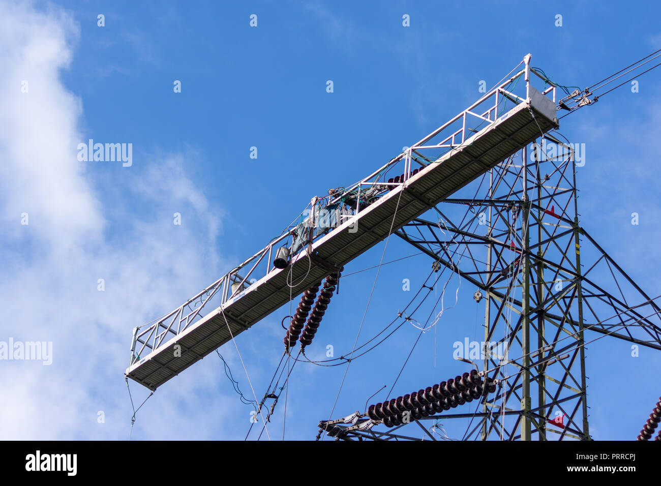 Large temporary work platform attached to an electricity pylon to allow work to be done on pylon and power lines Stock Photo
