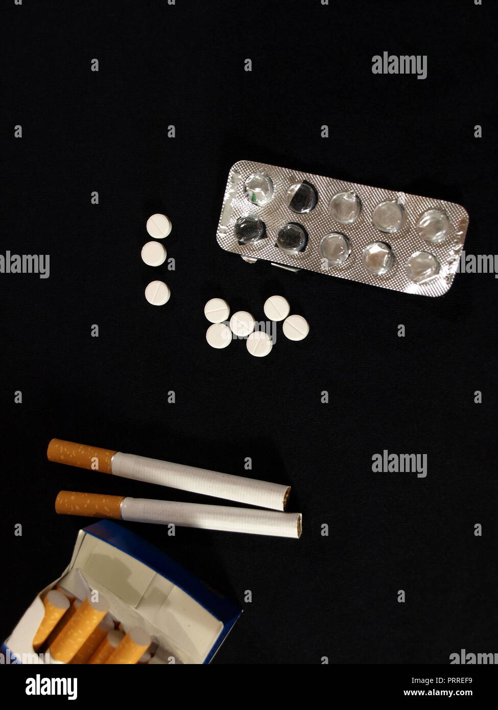 cigarette blister White tablets (pills) with blister and a pack of cigarettes Stock Photo