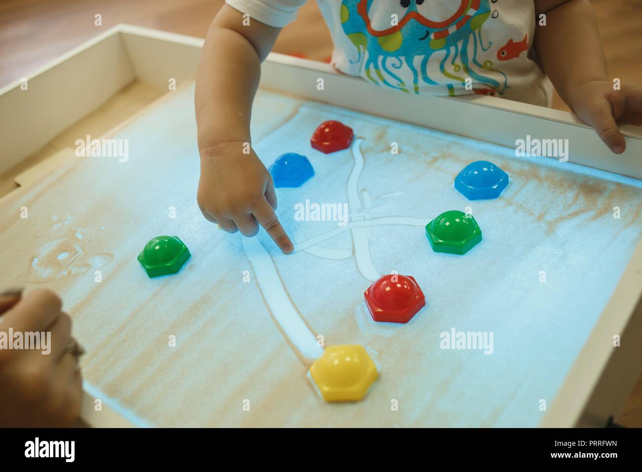 Children painting in the interactive sand box , sand animation