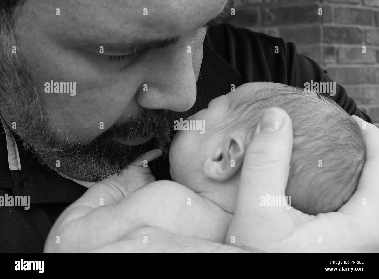 Close up portrait of a new father comforting his newborn Stock Photo