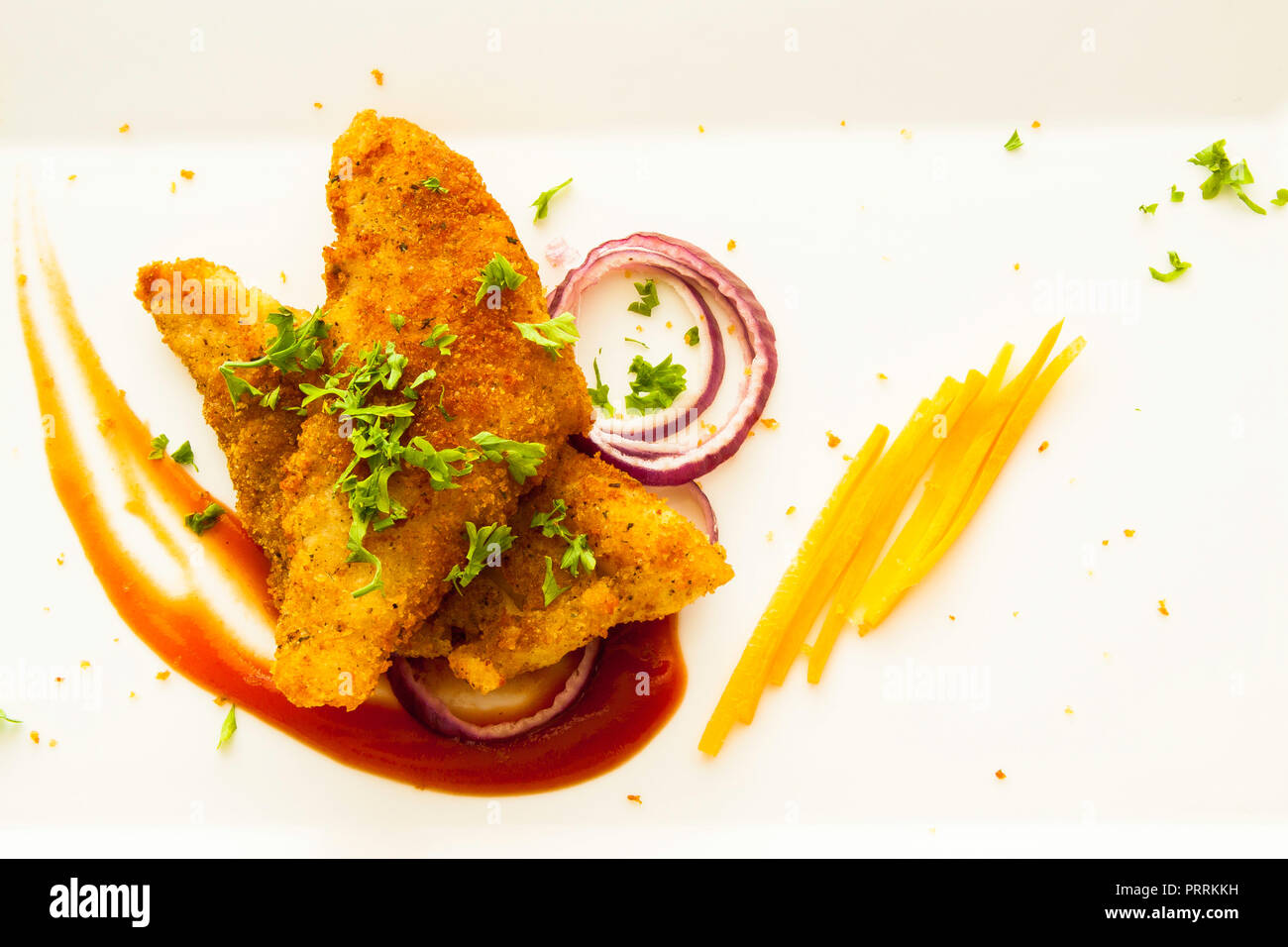 Fish fillet deep fried with bread crumbs and served on a white plate