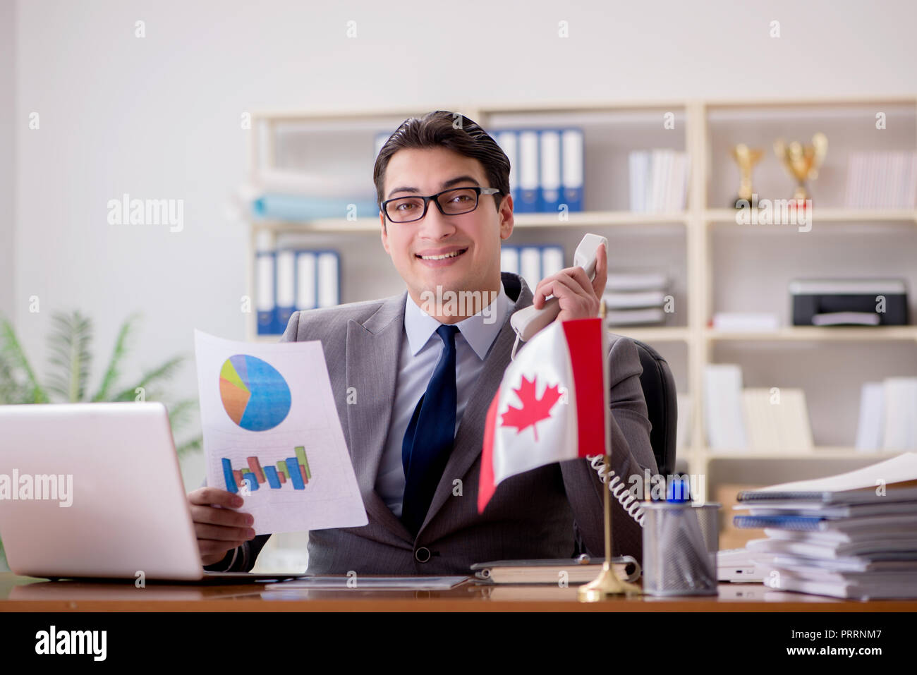 Businessman with Canadian flag in office Stock Photo - Alamy