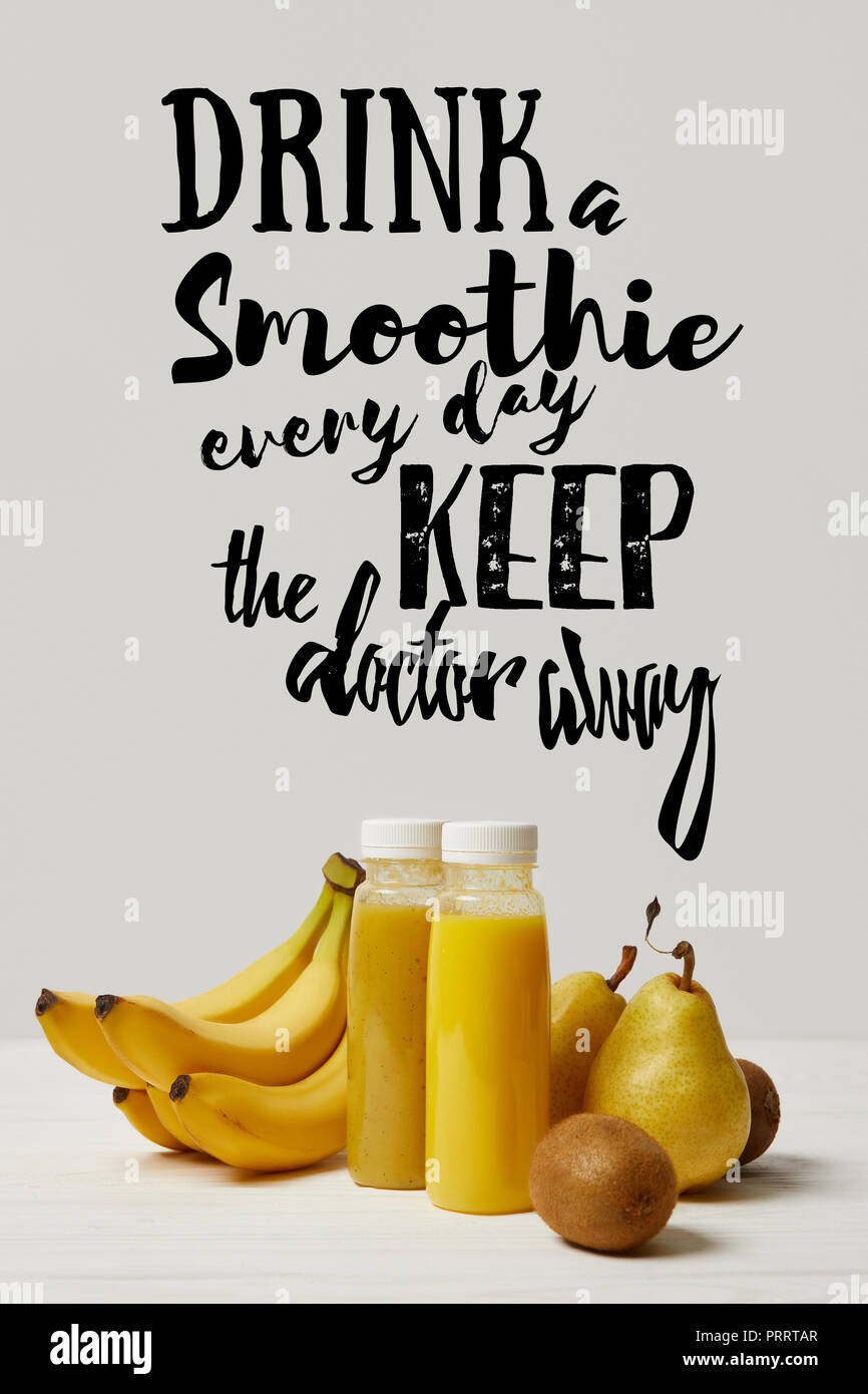 yellow detox smoothies in bottles with bananas, pears and kiwis on