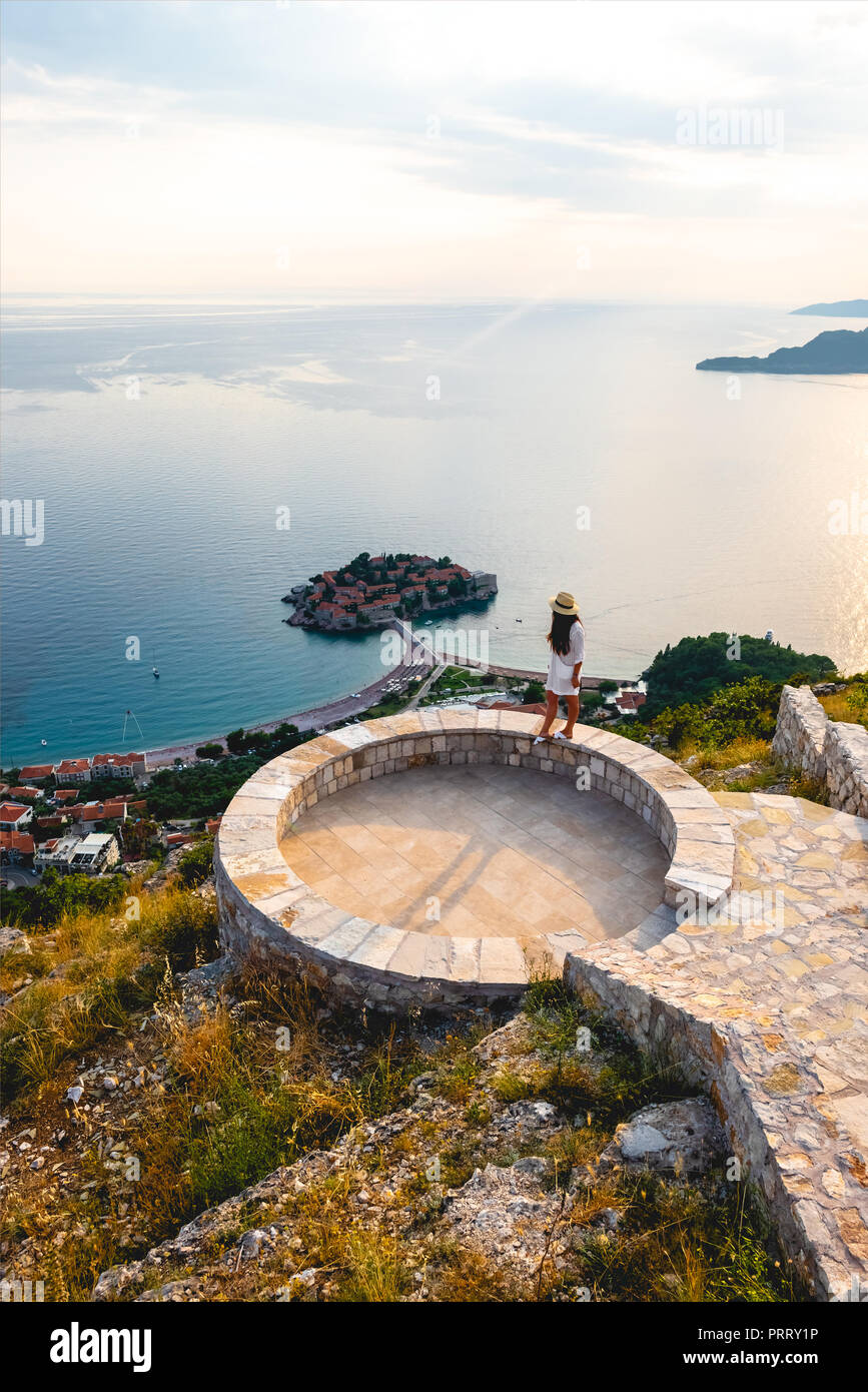 high angle view of woman standing on viewpoint near saint stephen island in Adriatic sea, Budva, Montenegro Stock Photo