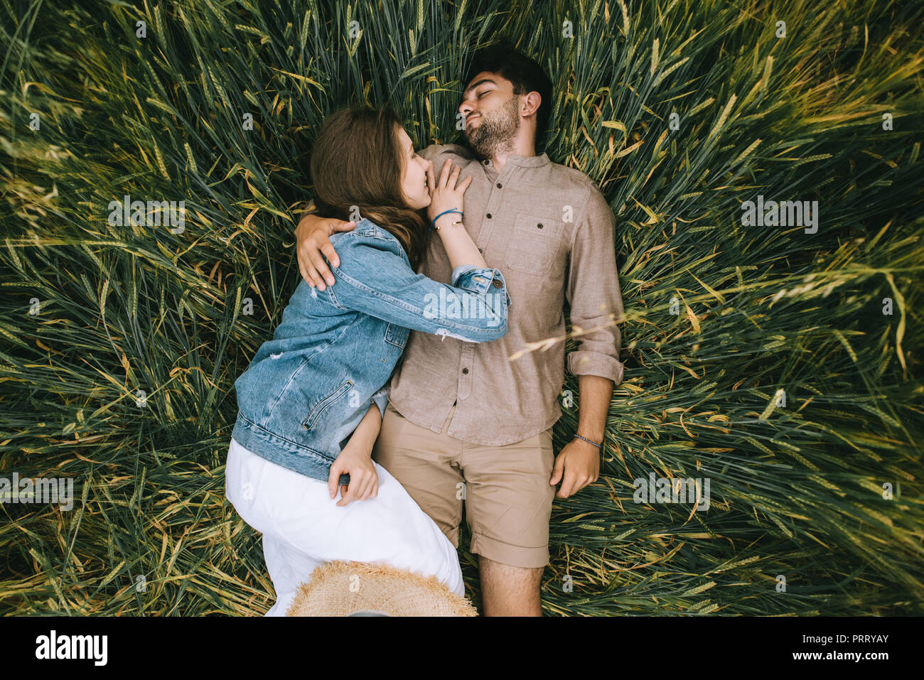 happy stylish couple lying in green grass Stock Photo - Alamy