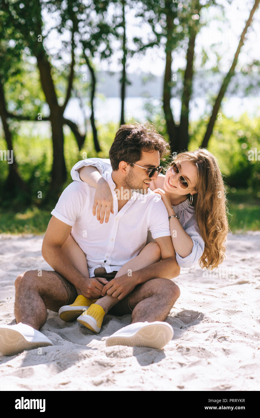 girlfriend hugging handsome boyfriend on sandy city beach Stock Photo ...
