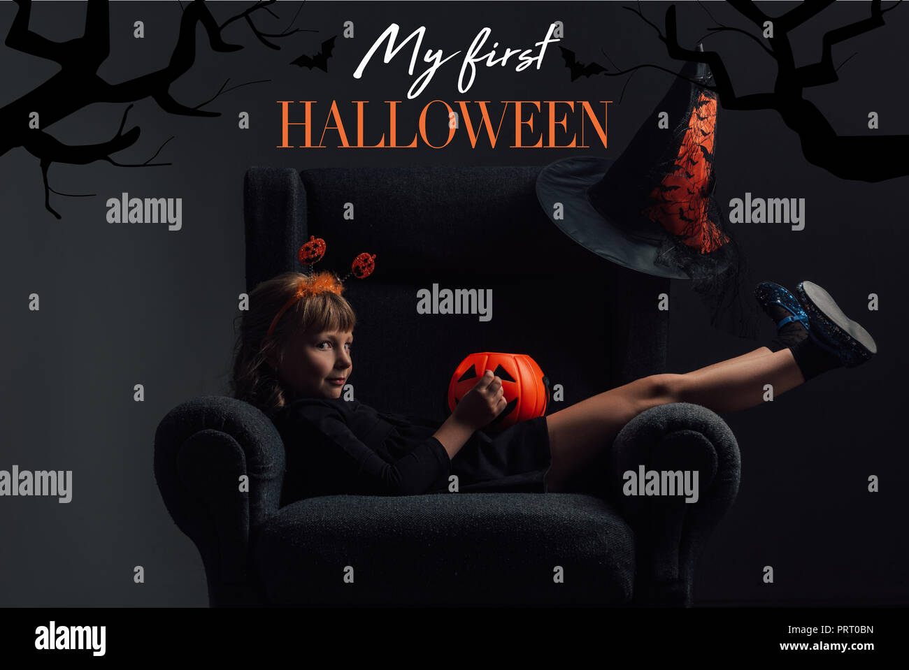 adorable kid in halloween costume resting in armchair in dark room