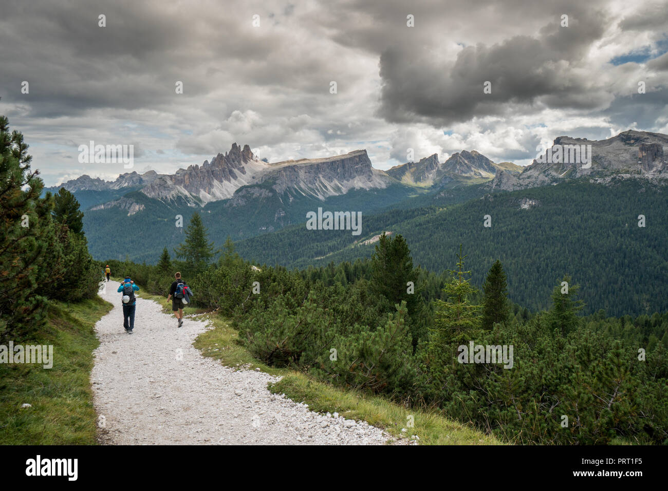 climbers walking down a road in a Dolomite mountain landscape after a hard climb Stock Photo