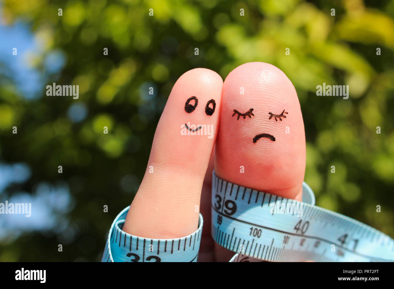 Finger art of couple with meter. The concept man is thin, woman is fat. Stock Photo