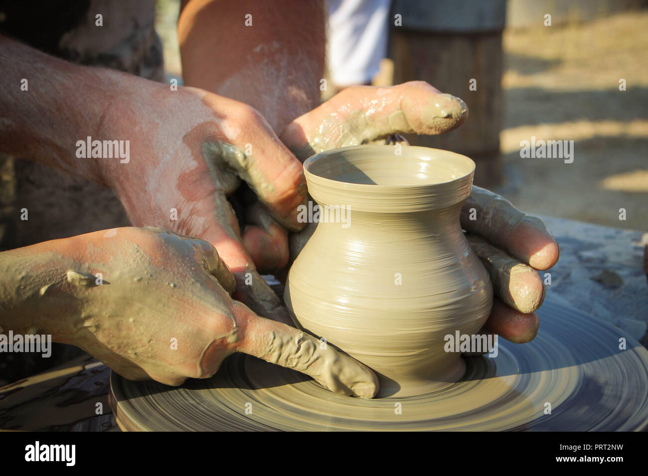 potter helps the child to make a vase from clay Stock Photo