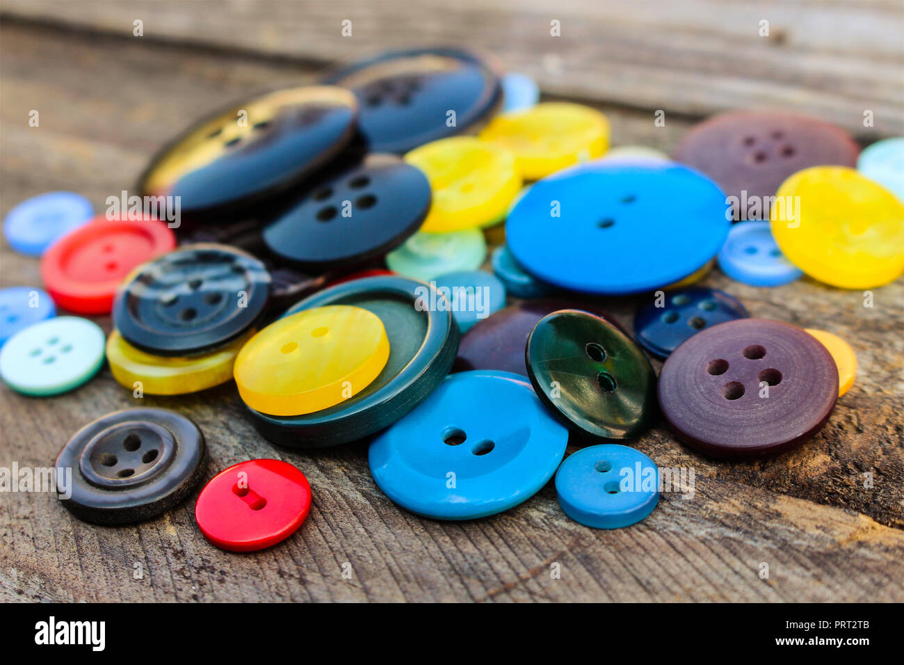Lots of colorful buttons for clothes on wooden background Stock