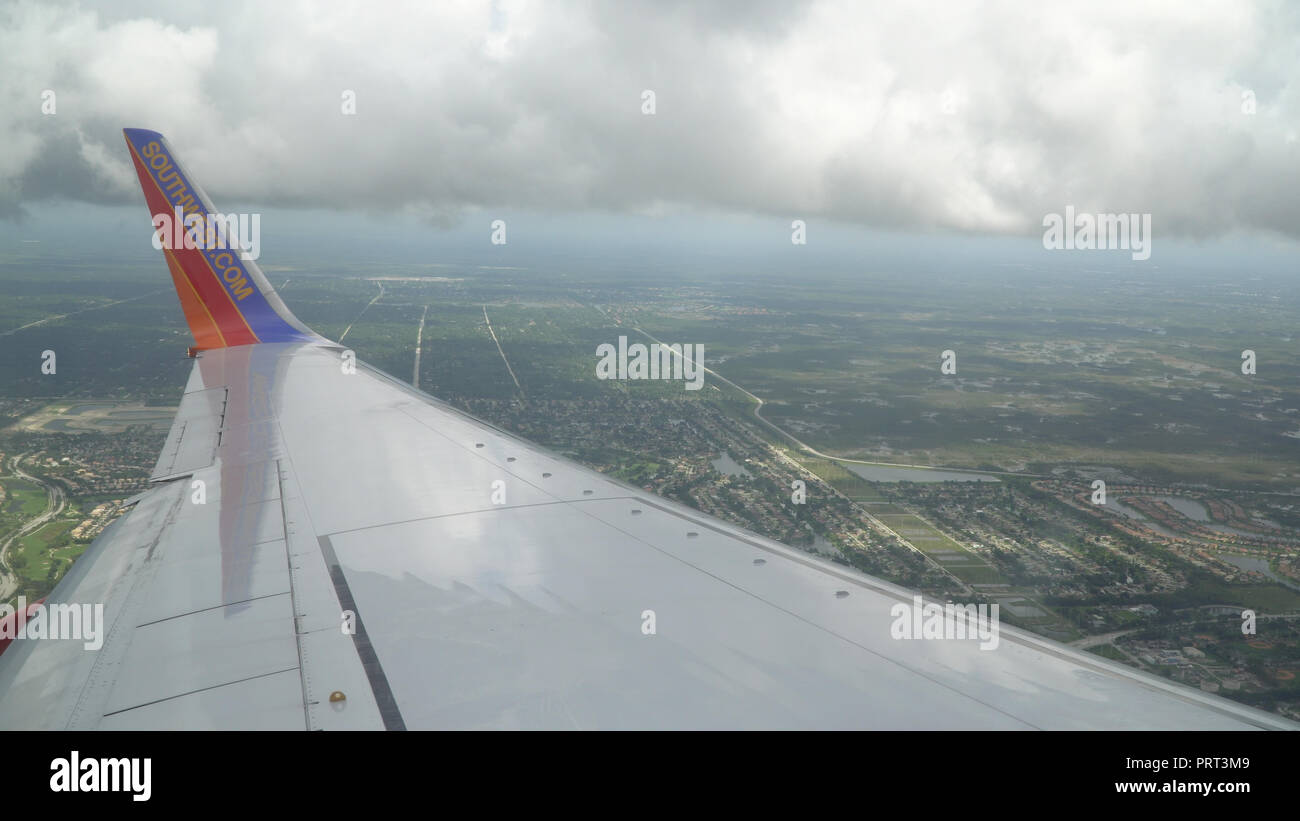 Florida, USA - Circa 2017: Southwest airlines Boeing 737 airplane wing painted business logo on wingtip. View over wing on decent to airplort ground b Stock Photo
