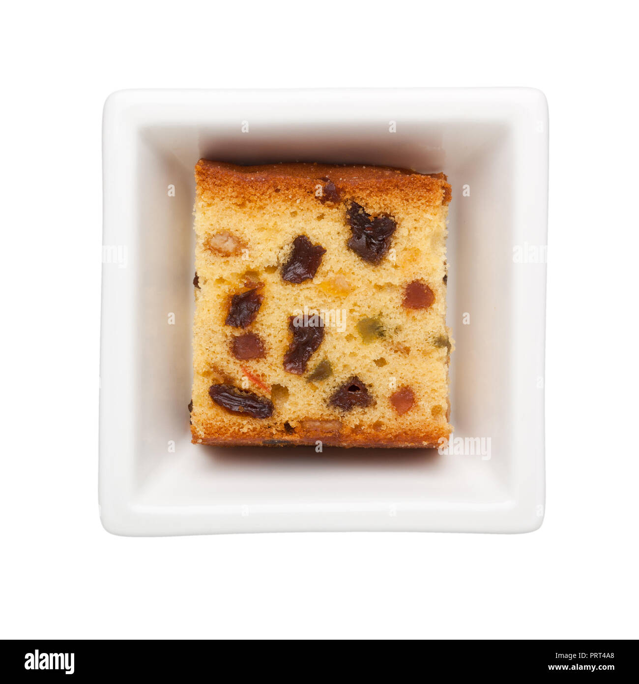 Slice of fruit cake in a square bowl isolated on white background Stock Photo