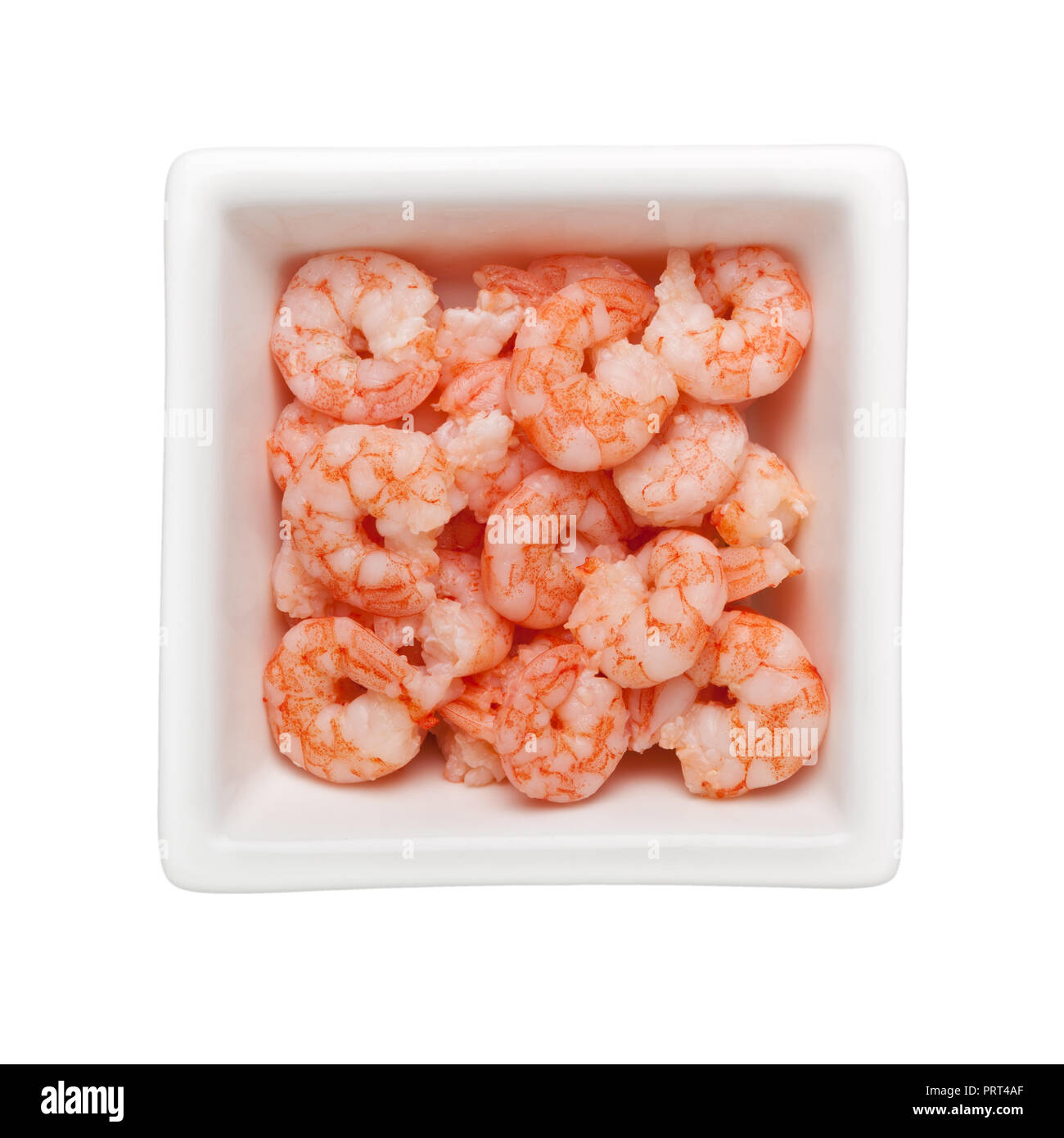 Pile of small cooked shrimps in a square bowl isolated on white background Stock Photo