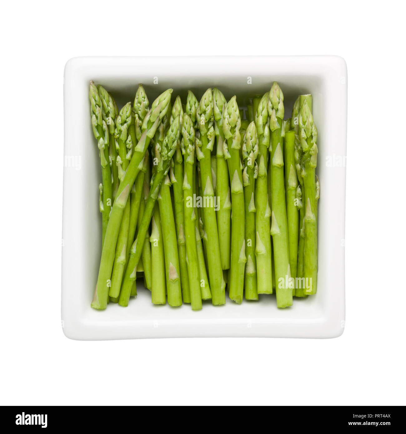 Pieces of asparagus in a square bowl isolated on white background; Stock Photo