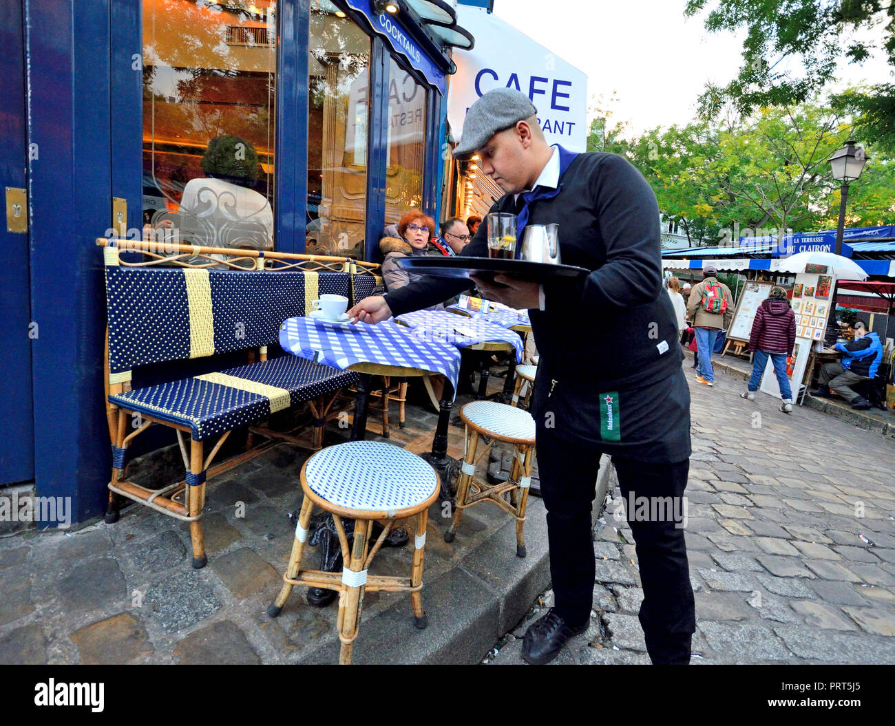 Paris, France. Waiter clearing away coffee cups froma table in Place du Tertre, Montmartre Stock Photo