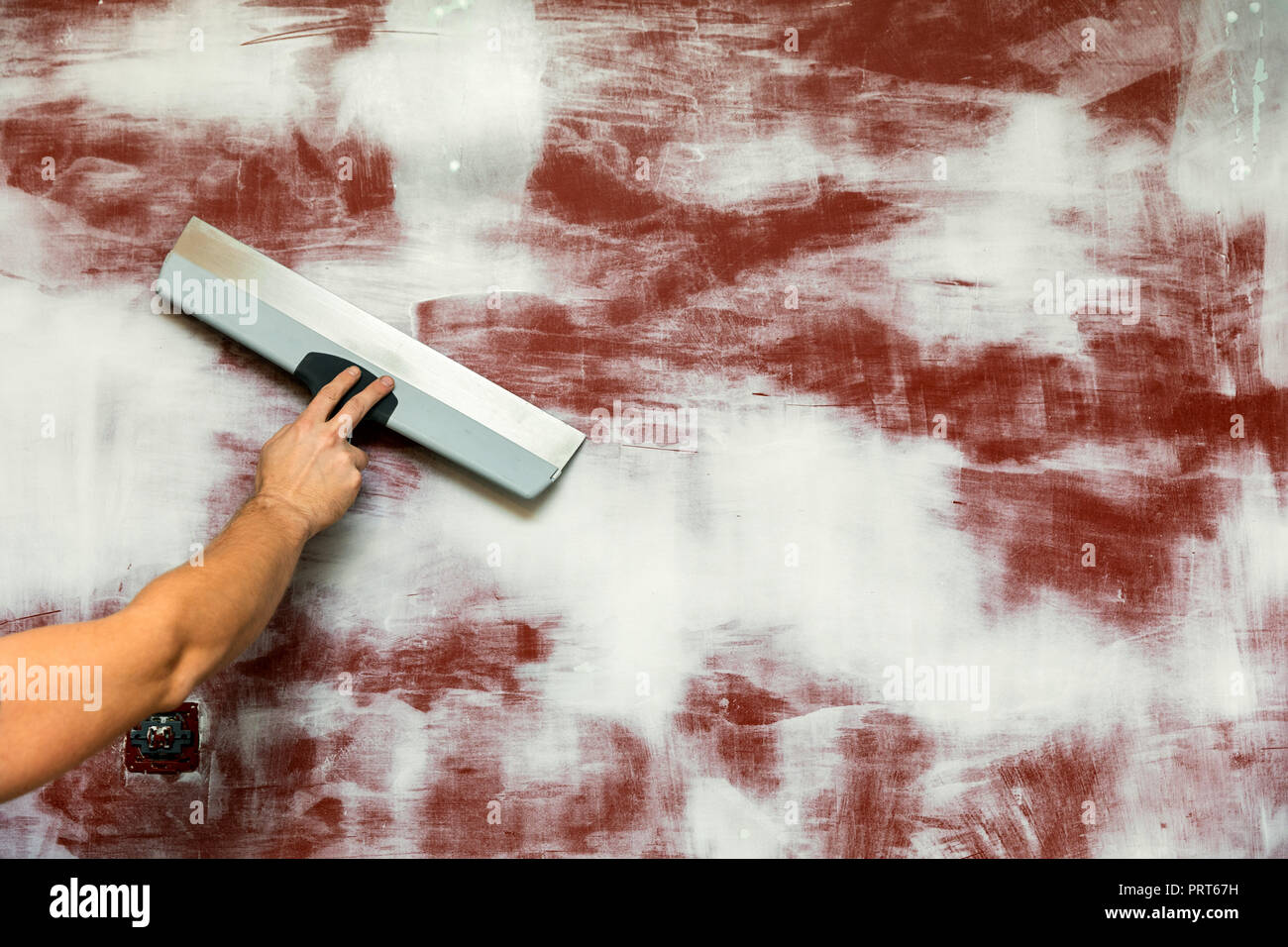 hand with taping knife plastering wall. copy space Stock Photo