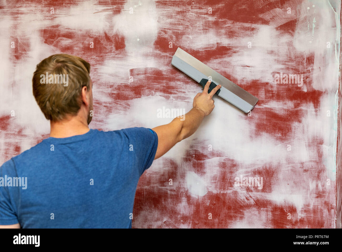 man plastering wall with taping knife Stock Photo